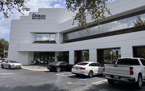Front of the two-story office building at 1020 W International Speedway Blvd, with its surface parking and tenant signage