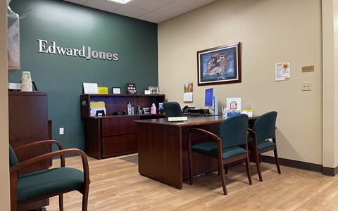 Reception area of a tenant suite with a desk, chairs and a dark green feature wall