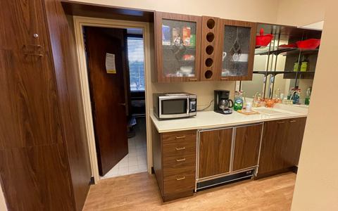 Break room with cabinets, counter and a microwave