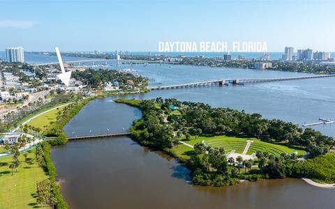 Annotated aerial of Daytona Beach with an arrow marking the building beside the riverfront park and amphitheater